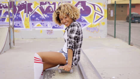 Trendy-young-woman-sitting-on-a-skateboard