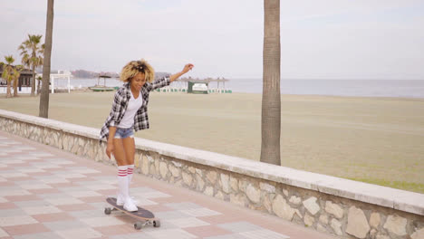 Junge-Frau-Beim-Skateboarden-An-Der-Strandpromenade