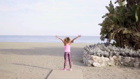 Single-woman-stretching-arms-outward-at-beach