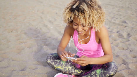 Frau-Sitzt-Am-Strand-und-Hört-Musik