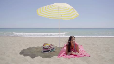 Young-lady-laying-down-on-beach-blanket