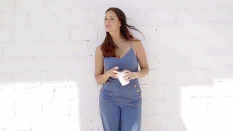 Young-woman-enjoying-a-cup-of-takeaway-coffee