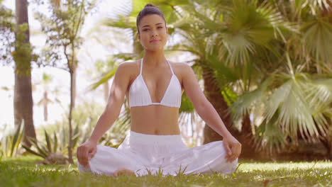 Mujer-Joven-Meditando-En-Un-Jardín-Tropical.