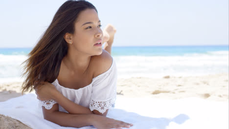 Young-woman-relaxing-in-the-shade-of-an-umbrella