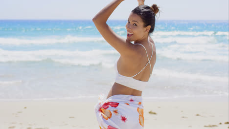 Playful-young-woman-dancing-on-the-beach