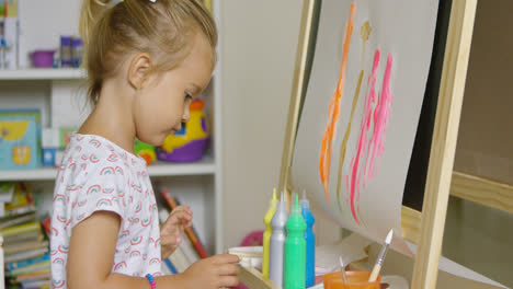 Cute-little-blond-girl-painting-with-watercolors