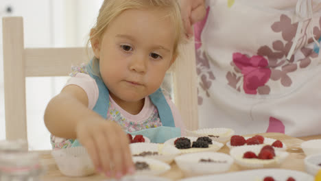 Kind-und-Frau-Bereiten-Muffins-Auf-Dem-Tisch-Zu