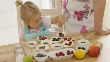 Kind-und-Frau-Bereiten-Muffins-Auf-Dem-Tisch-Zu