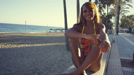 Sexy-young-woman-sitting-waiting-on-a-wall