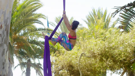 Female-acrobat-working-outdoors-on-silk-ribbons