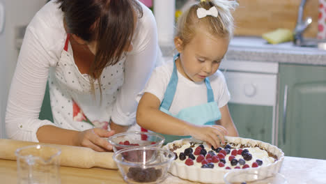 Junge-Mutter,-Die-Ihrer-Kleinen-Tochter-Beim-Backen-Zusieht