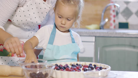 Madre-E-Hija-Añadiendo-Bayas-Frescas-A-Un-Pastel