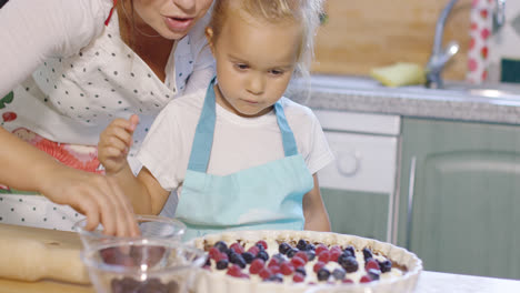 Madre-E-Hija-Añadiendo-Bayas-Frescas-A-Un-Pastel