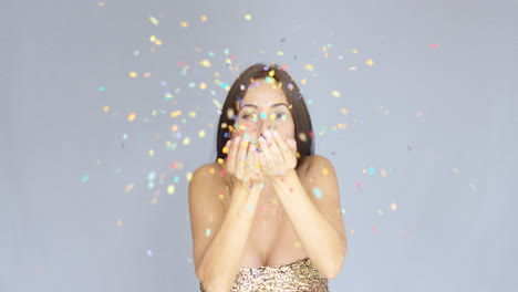 Young-woman-blowing-colorful-New-Year-confetti