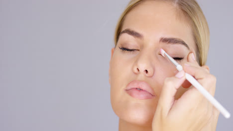 Mujer-Joven-Aplicando-Maquillaje-De-Ojos-En-El-Párpado.