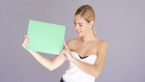 Happy-attractive-young-woman-with-a-blank-sign