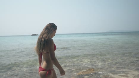 Chica-En-Bikini-Rojo-Camina-Por-La-Playa-Tropical-Contra-El-Océano