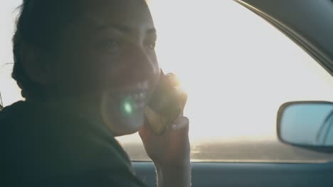joyful-girl-talks-on-phone-and-smiles-against-speeding-cars