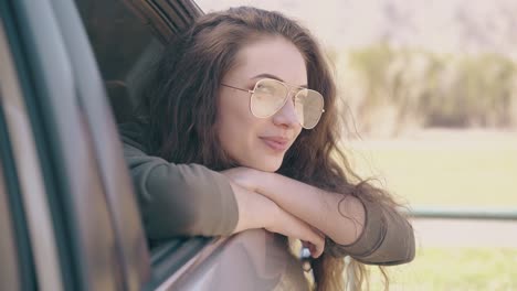Hübsche-Träumende-Frau-Mit-Brille-Schaut-Aus-Dem-Autofenster