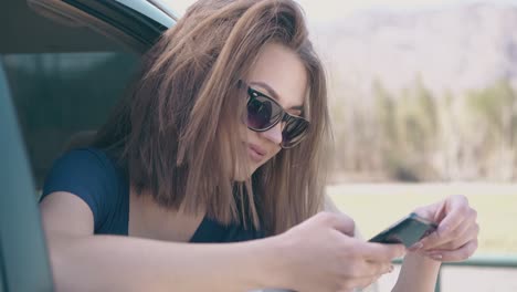 girl-uses-mobile-device-inside-auto-on-nice-day-close-view