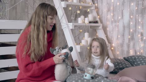 Blonde-Mutter-Und-Tochter-Spielen-Mit-Weihnachtsspielzeug-Auf-Dem-Bett