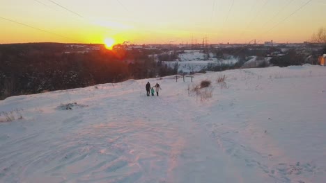 parents-and-child-wave-hands-standing-against-winter-sunset