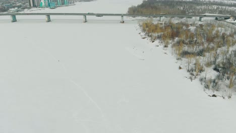 white-frozen-river-with-tremendous-bridge-aerial-view