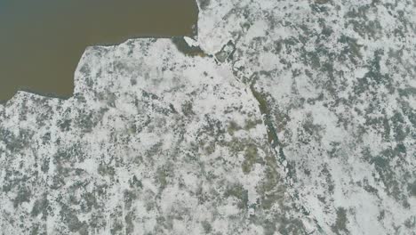 Flycam-Filmt-Ungewöhnliche-Eisoberfläche-Eines-Großen-Grauen,-Zugefrorenen-Flusses