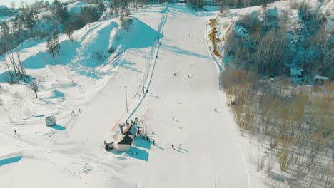Piste-Mit-Skilift-Auf-Verschneitem-Hügel-Am-Wintertag,-Obere-Ansicht
