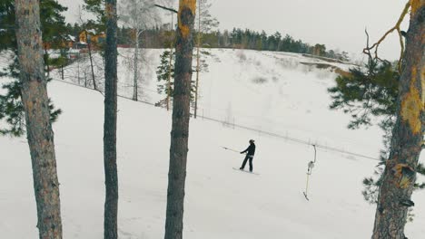 Skifahrer-Hält-Schlepplift-Poma-Auf-Schneebedecktem-Hügel-Aus-Der-Vogelperspektive