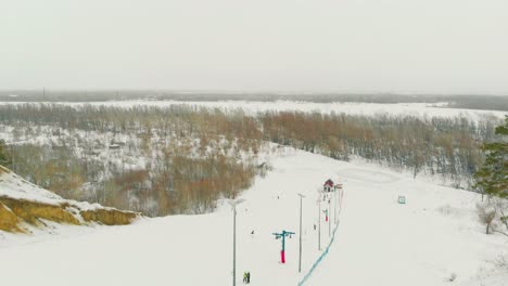 Ski-Anfängerstrecke-Und-Seillift-Auf-Schneebedecktem-Hügel-Mit-Blick-Auf-Den-Oberen-Teil