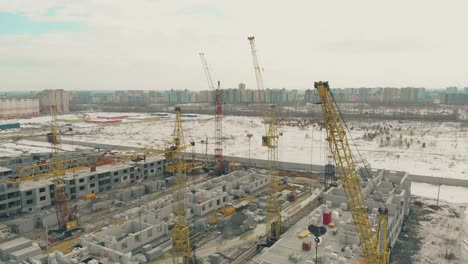 tower-cranes-at-construction-site-on-winter-day-upper-view