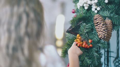 little-girl-touches-berries-on-Christmas-wreath-in-room