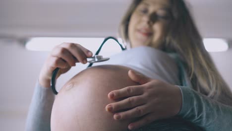 La-Mujer-Embarazada-Escucha-Los-Latidos-Del-Corazón-Del-Bebé-Con-El-Primer-Plano-De-La-Herramienta.