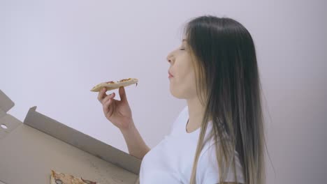 pregnant-lady-eats-pizza-from-box-on-white-backgrounder