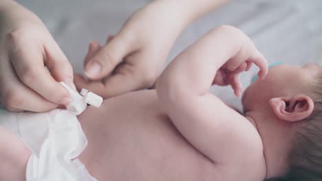 Sorgfältige-Hände-Der-Mutter-Desinfizieren-Die-Nabelschnur-Des-Süßen-Säuglings