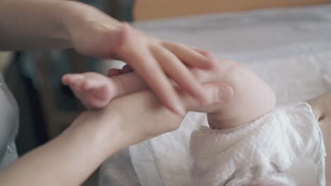 pediatrician-holds-infant-leg-and-does-hypertonus-massage