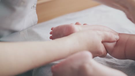 Kinderarzt-Hält-Neugeborenes-Babybein-Und-übt-Massage