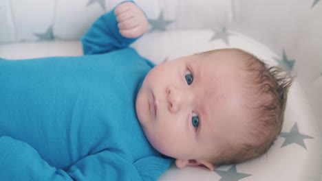 Besorgtes-Baby-Mit-Blauen-Augen-Ruht-In-Einem-Weichen-Schlafkokon