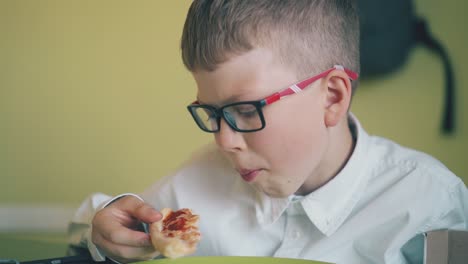 Schulkind-Isst-Abendessen-Mit-Köstlicher-Pizza-Am-Tisch-In-Nahaufnahme