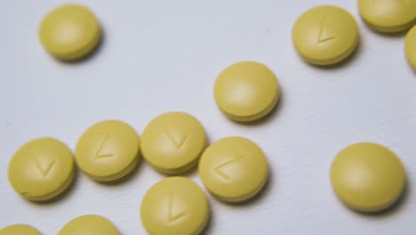 Gelbe-Pillen-Mit-Markierungen-Liegen-Auf-Hellem-Hintergrundmakro