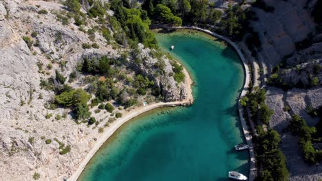 Croatia-hidden-gem,-turquoise-ocean-bay-surrounded-by-steep-cliffs,-aerial