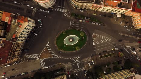 Ascend-top-down-shot-showing-traffic-on-roundabout-in-Naples-City-during-golden-hour,-Italy---rising-flight