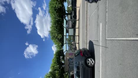 POV-Looking-Out-Window-Driving-Past-Urban-Street-Past-Traffic-In-Frankfurt-On-Sunny-Day