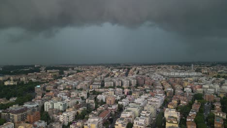 Aerial-drone-backward-moving-shot-over-dark-rain-clouds-hovering-over-the-residential-buildings-in-the-city-of-Rome,-Italy-at-daytime