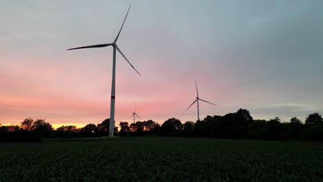 Silhouette-of-wind-turbines-and-vibrant-sky,-zoom-out-view
