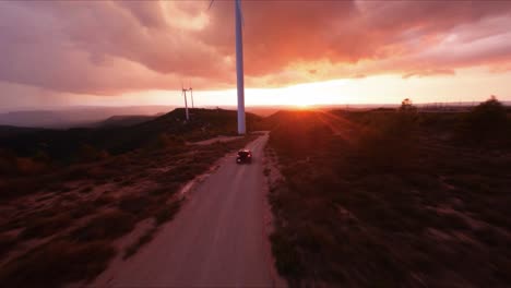Cinematic-FPV-aerial-following-a-Hummer-driving-along-a-dirt-road-into-a-scenic-sunset