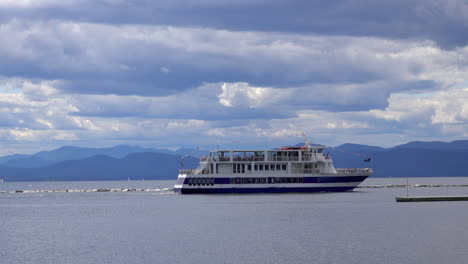 A-riverboat-tour-gets-underway-under-an-overcast-sky-with-mountains
