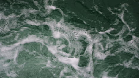 Slow-motion-low-shot-above-fresh-broken-waves-creating-bubbles-on-the-surface