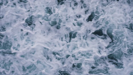 Slow-motion-top-down-shot-of-waves-crashing-along-the-beach-creating-patterns